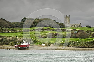 Fishing Boat Moored At Lelant, Cornwall, With St. Uny Church In Background