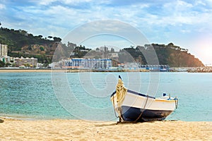 Fishing boat moored on sandy beach. Blanes, Spain