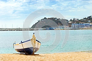 Fishing boat moored on sandy beach. Blanes, Spain