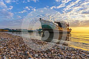 A fishing boat moored at the shore on a beautiful sunrise