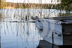 A fishing boat moored to the shore of the lake. Old fishermen& x27;s