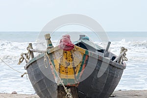 A fishing boat nautical vessel used in fishing industry spotted in a tropical sea beach. Vertical horizon. Mode of water
