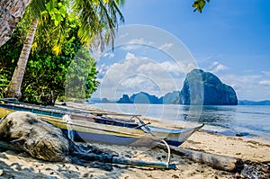 Fishing boat and net on shore under palms.Tropical island landscape. El- Nido, Palawan, Philippines