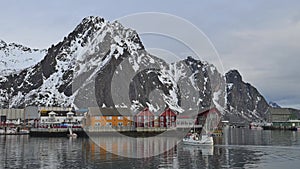 Fishing boat in the Norwegian sea in winter. Lofoten Islands winter scenery with traditional fishing boats lying in