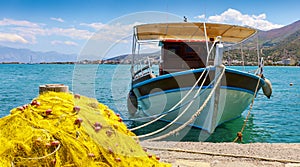 Fishing Boat off the coast of Crete with marine rope and fishing net in the foreground