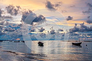 Fishing boat in perfectly calm sea water like glass with the clouds in the sky, long Exposure taken during sunrise