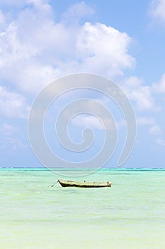 Fishing boat on picture perfect white sandy beach with turquoise blue sea, Paje, Zanzibar, Tanzania. photo