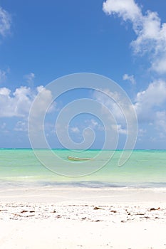 Fishing boat on picture perfect white sandy beach with turquoise blue sea, Paje, Zanzibar, Tanzania. photo