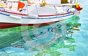 Fishing boat reflected on sea Aegina island Greece