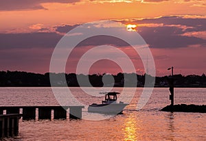 Fishing boat returning home at sunset