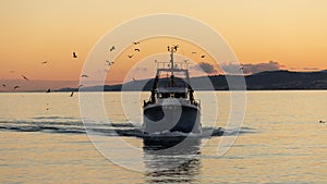 A fishing boat returning to port in Spain.