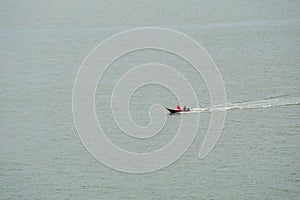 Fishing boat sailing on sea surface. Aerial Shot Over Speed Boat with small waves in Ocean. Fast speed boat moving on the water