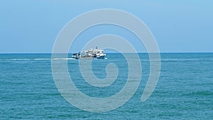 Fishing Boat Sailing .Ship Floats On Sea Surface With Blue Sky Leaving Path Sea Foam Water. Real time.