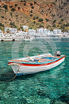 Fishing boat and the scenic village of Loutro in Crete Greece