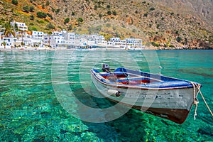 Fishing boat and the scenic village of Loutro in Crete Greece