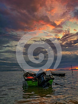 Fishing boat in sea against sky during sunset