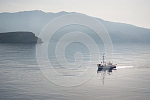 A fishing boat in the sea, early morning. Ios island, Cyclades, Greece