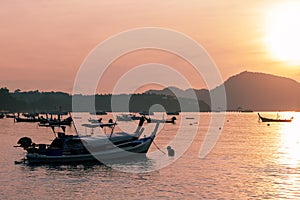 Fishing boat in the sea in morning time with beautiful sunrise and reflection in the water at phuket andaman sea thailand