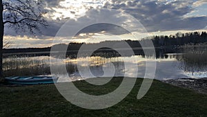 a fishing boat on the shore by the lake surrounded by a forest