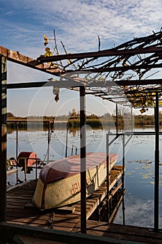 A fishing boat, with a side number, lies upside down on the pier, after a successful fishing trip.