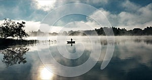 Fishing from a boat with a spinning rod on a foggy morning