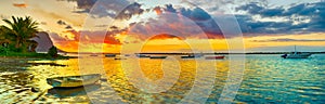 Fishing boat at sunset time. Le Morn Brabant on background. Panorama landscape