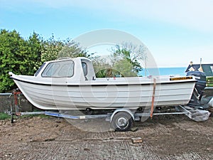 Fishing Boat white on a trailer concrete yard. fish