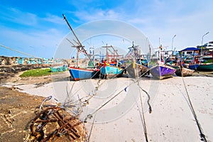 Fishing boats aground on the beach over cloudy sky at Prachuap K