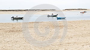 Fishing boats anchored off a beach in an estuary in Benodet