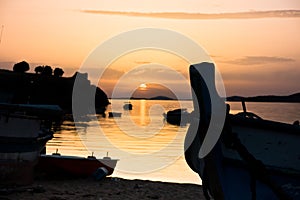 Fishing boats on a beach in front of ruins of a roman fortress at sunset, Sithonia