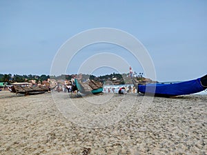 Fishing boats on beach with lighthouse