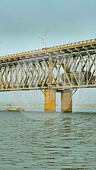 Fishing boats close to the rail cum road bridge on the mighty Godavari river in Rajahmundry, Andhra Pradesh, India