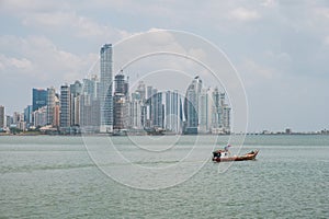 Fishing boats at commercial fish market harbour with skyline bac