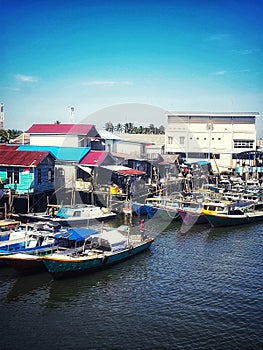 Fishing boats docked at the mouth of the river. Seen an angler fishing on a boat.