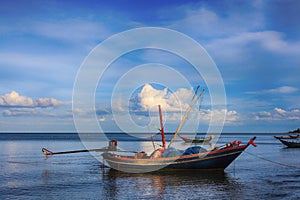 Fishing boats float in the blue sea in the evening.