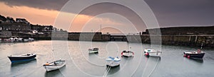 Fishing boats in harbour at sunrise long exposure image