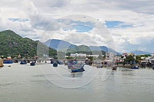Fishing boats, junks, near the coastline on the river photo