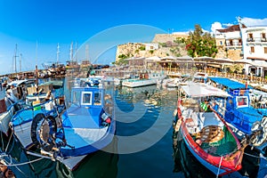 Fishing Boats moored in Kyrenia Girne harbour with restaurants