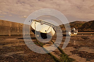 Fishing boats moored, at low tide, at Nefyn Port, Gwynedd, North Wales.