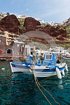 Fishing boats at Oia village harbor, below Caldera cliff at Santorini island