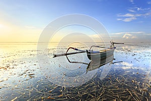 Fishing boats populate the shoreline at the Sanur beach photo