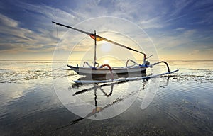 Fishing boats populate the shoreline at the Sanur Beach photo