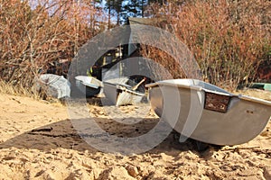 Fishing boats that are pulled ashore. Small boats in front of fisherman`s cottage.