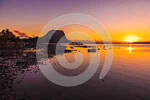 Fishing boats in a quiet ocean at sunset time. Le Morn mountain in Mauritius