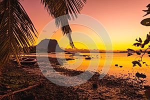 Fishing boats in a quiet ocean at sunset time. Le Morn mountain at Mauritius