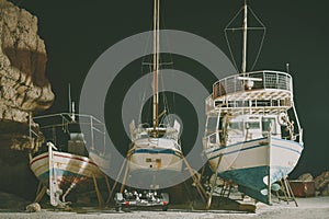 Fishing boats on repair in the port at night