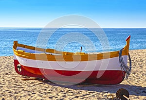 Fishing boats rest on a golden sand beach