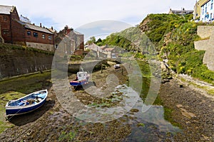 Fishing boats resting on the bed of Staithes Beck at low tide