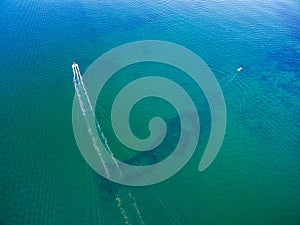 Fishing boats sailing across shallow ocean water