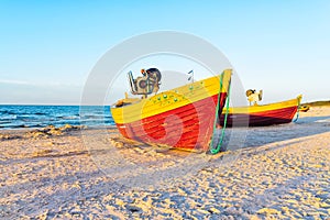 Fishing boats on the sandy beach during sunset